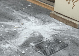 Boulder that has fallen from building in Italy into a busy sidewalk.