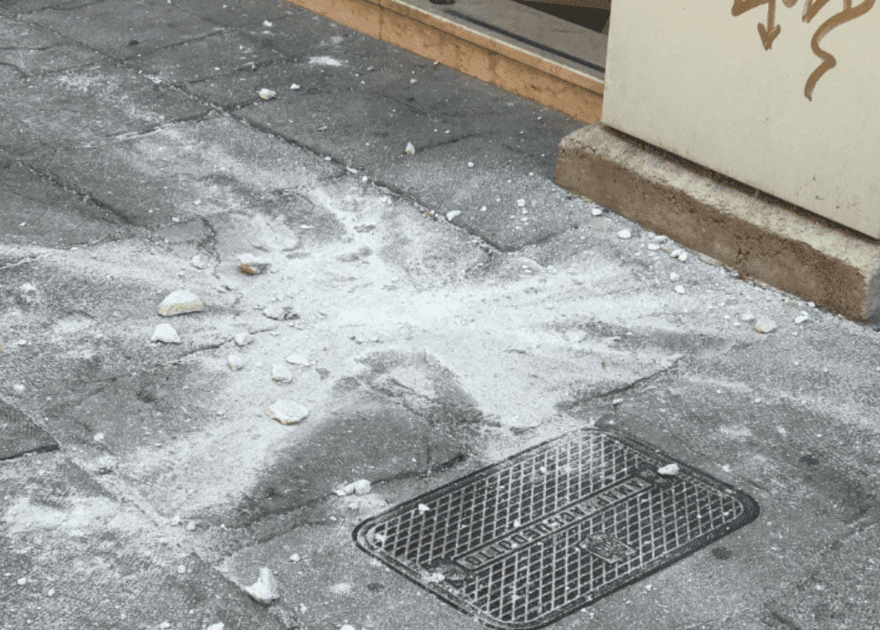 Boulder that has fallen from building in Italy into a busy sidewalk.