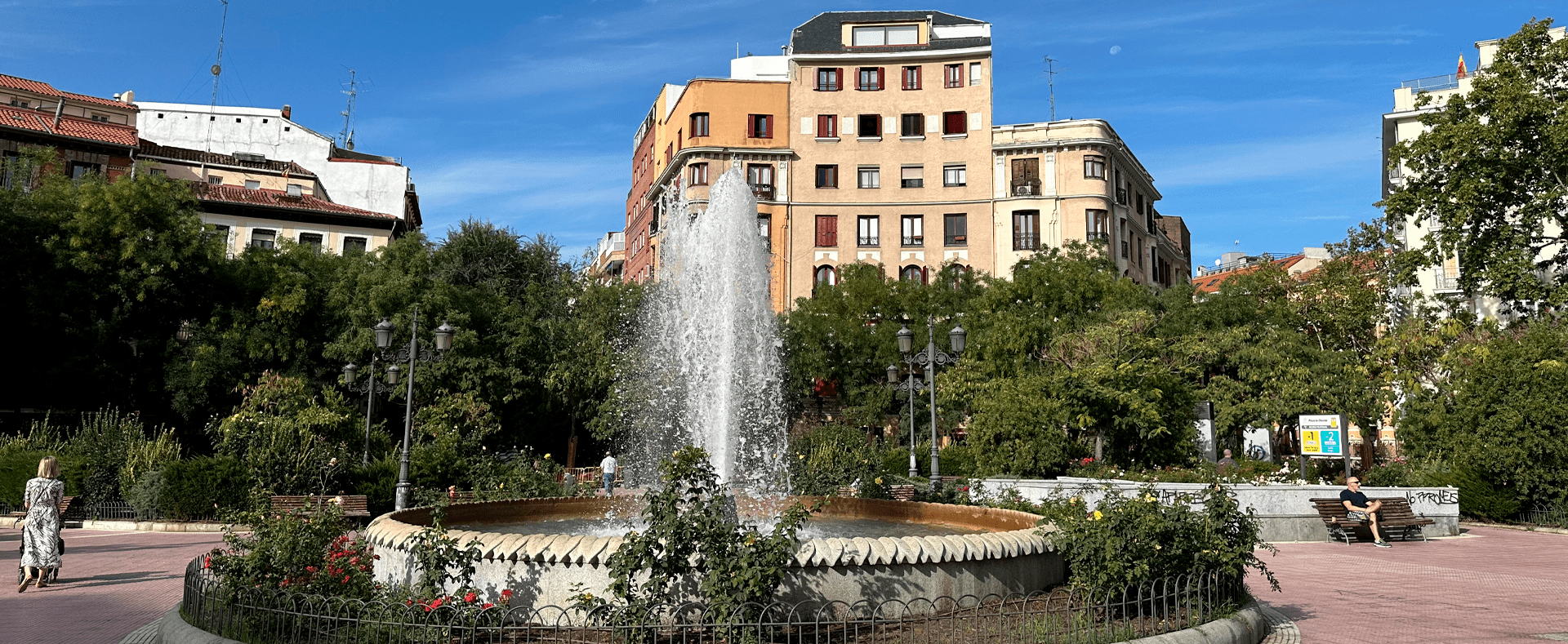 Fountain squirting water in Plaza Olavide, in Madrid, Spain. Apartment buildings in the background.